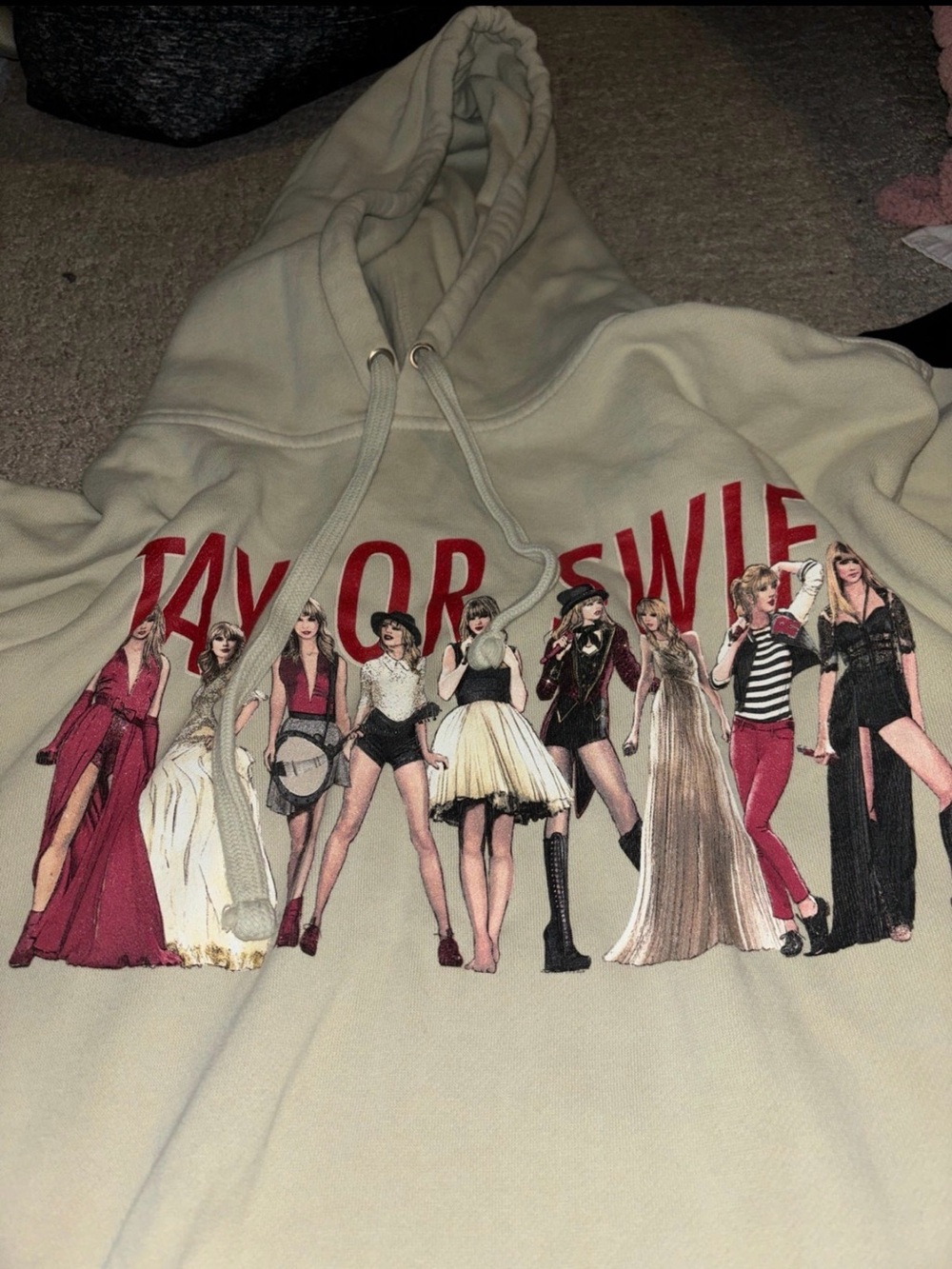 Taylor Swift Beige Hoodie with Red Logo and Multi-Figure Graphic